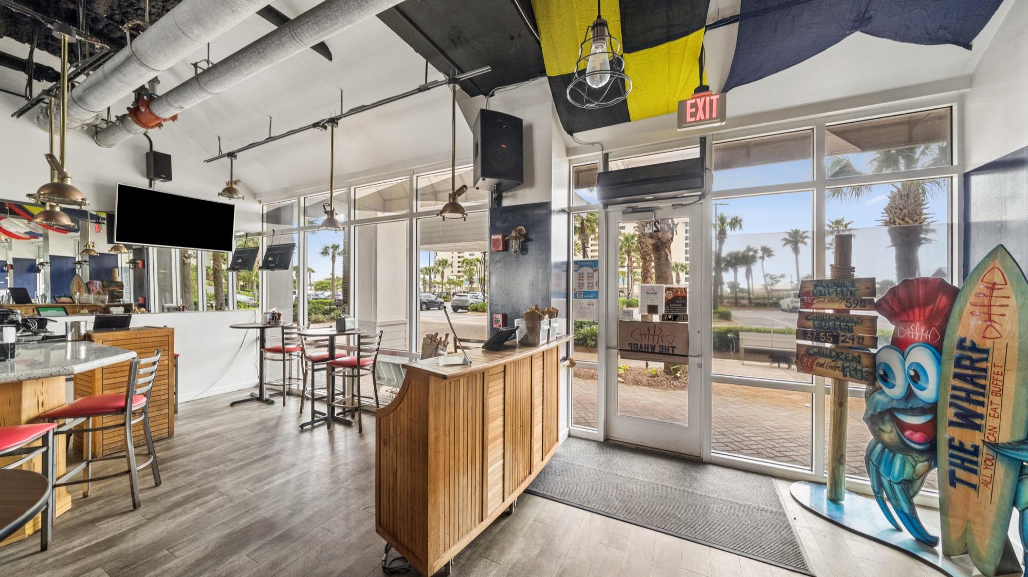 Beachfront restaurant bar with wood paneling, pennant flags and Gulf views, photographed on the Florida Panhandle