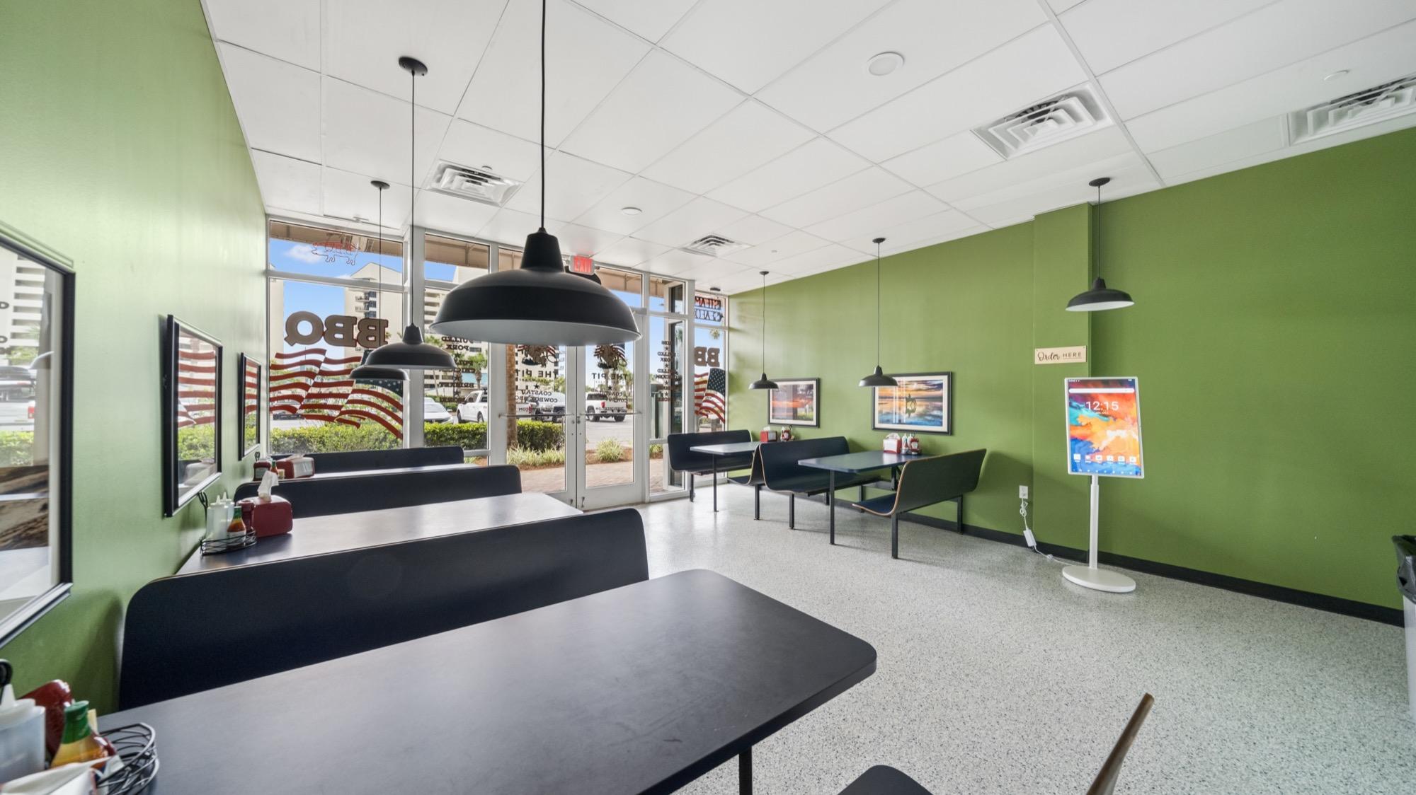 Fast-casual restaurant dining room with green walls and pendant lights, photographed on the Florida Panhandle