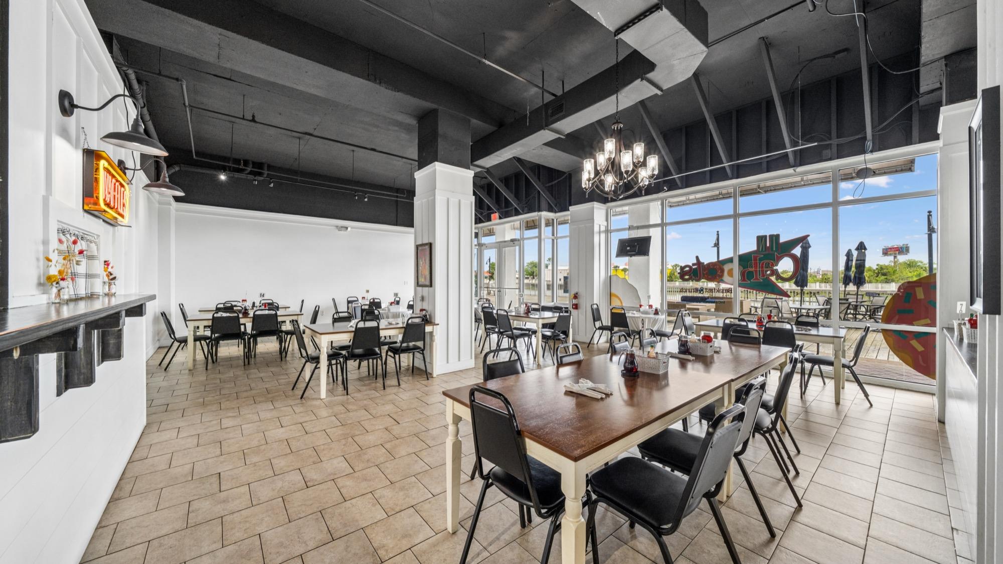 Hotel dining room with a chandelier and floor-to-ceiling windows, photographed on the Florida Panhandle