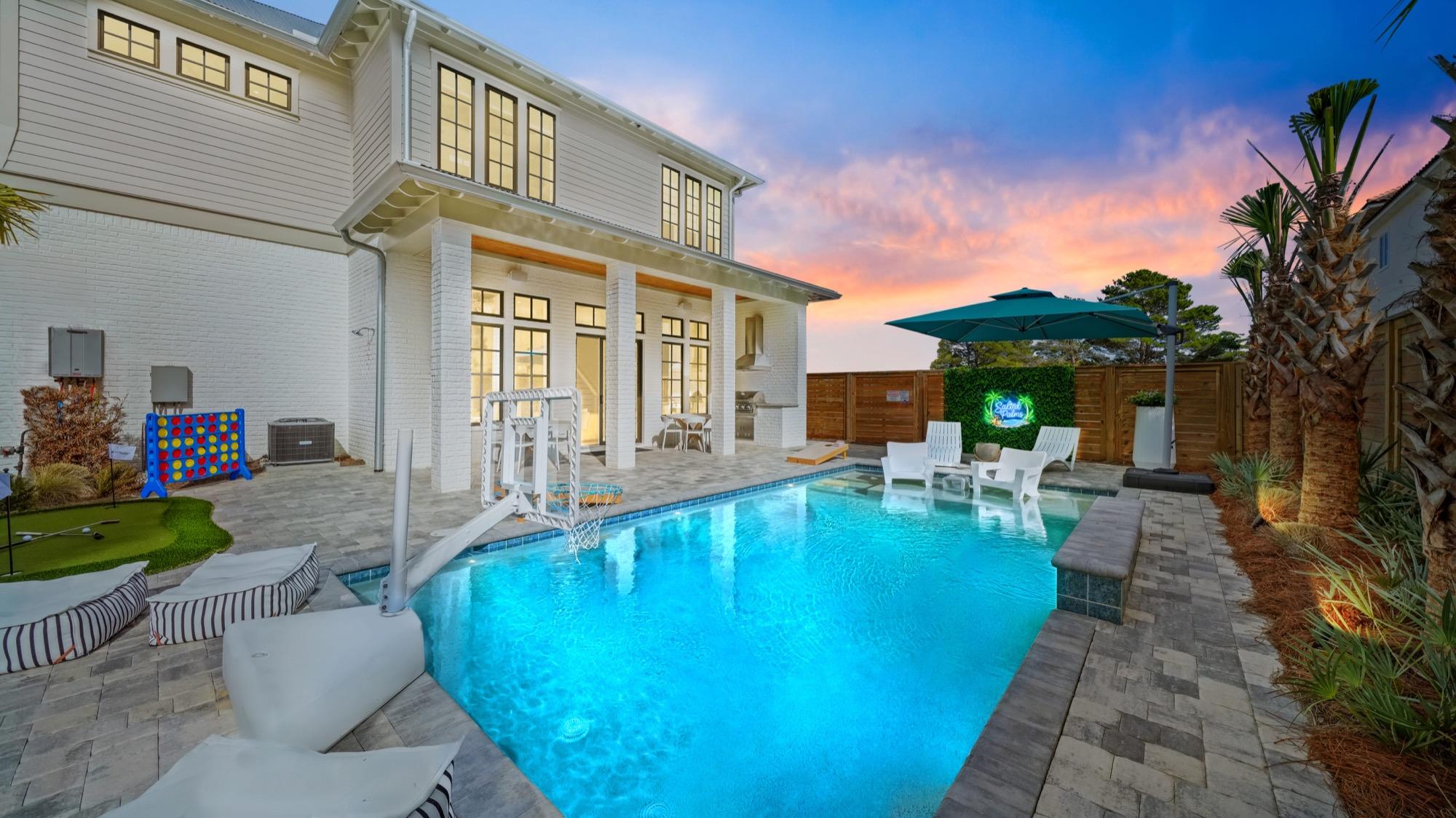 Backyard pool and outdoor living space of a white home at dusk, photographed on the Florida Panhandle