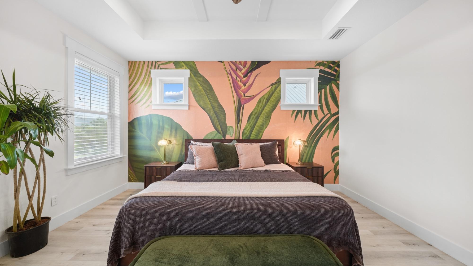 Bedroom with a pink tropical palm-leaf mural accent wall, photographed on the Florida Panhandle