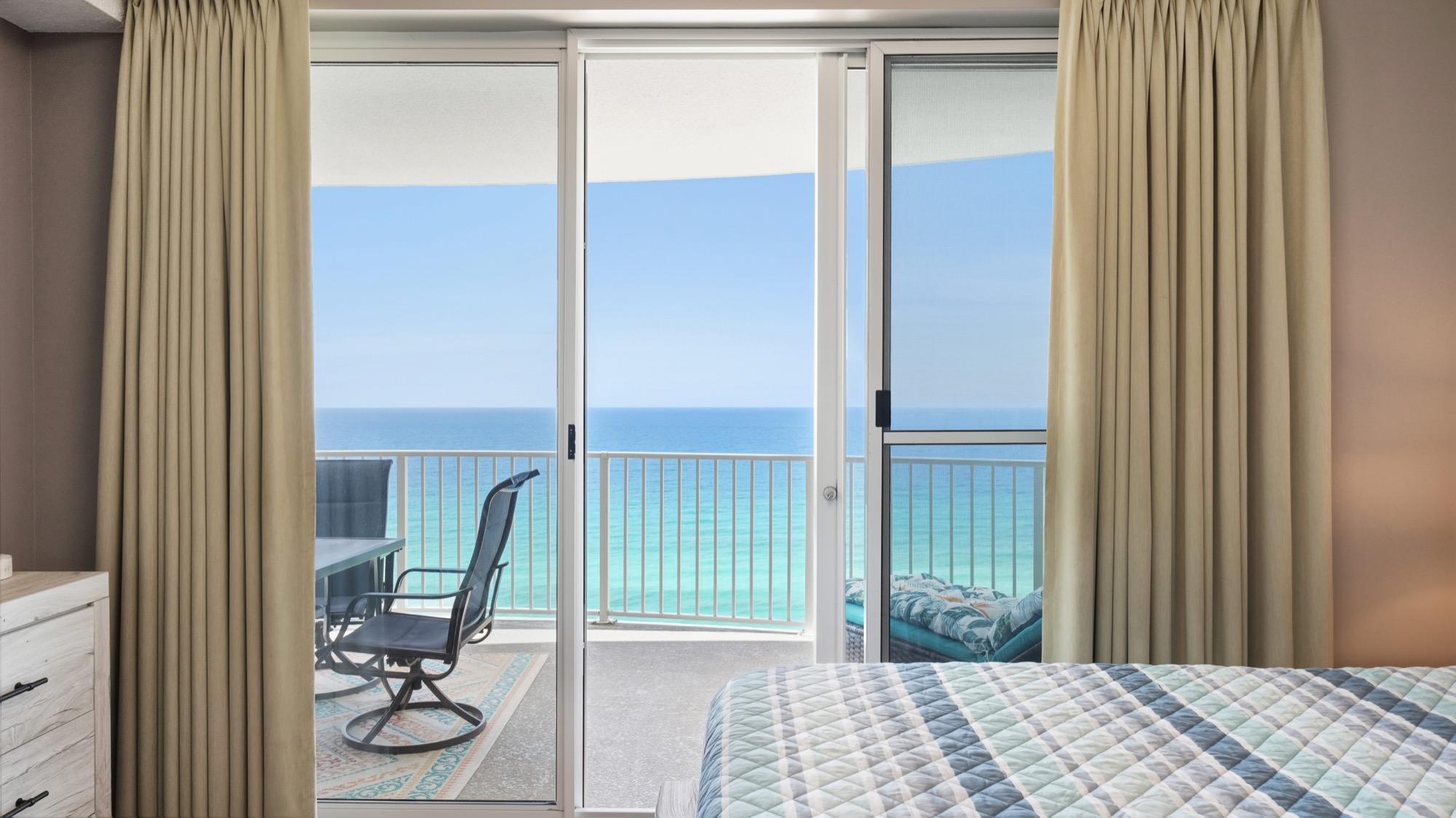 Bed facing balcony doors that open to the emerald Gulf, photographed on the Florida Panhandle